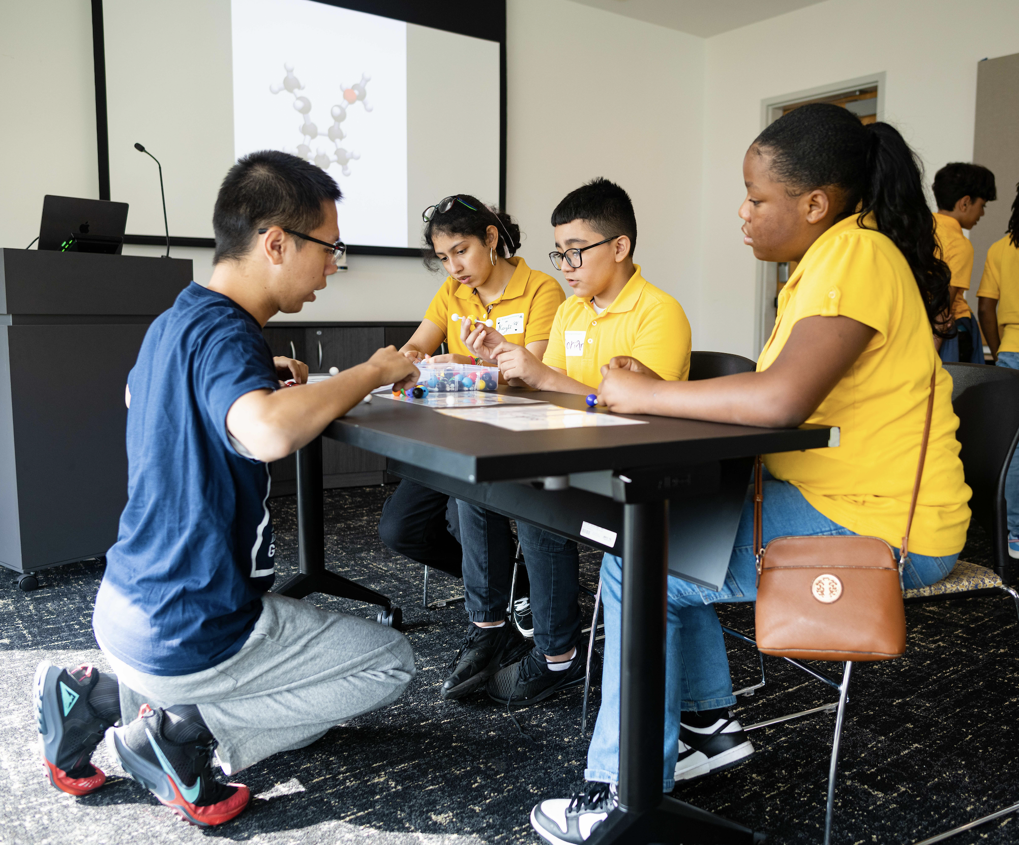 Graduate students and middle school students work together on molecular modeling.