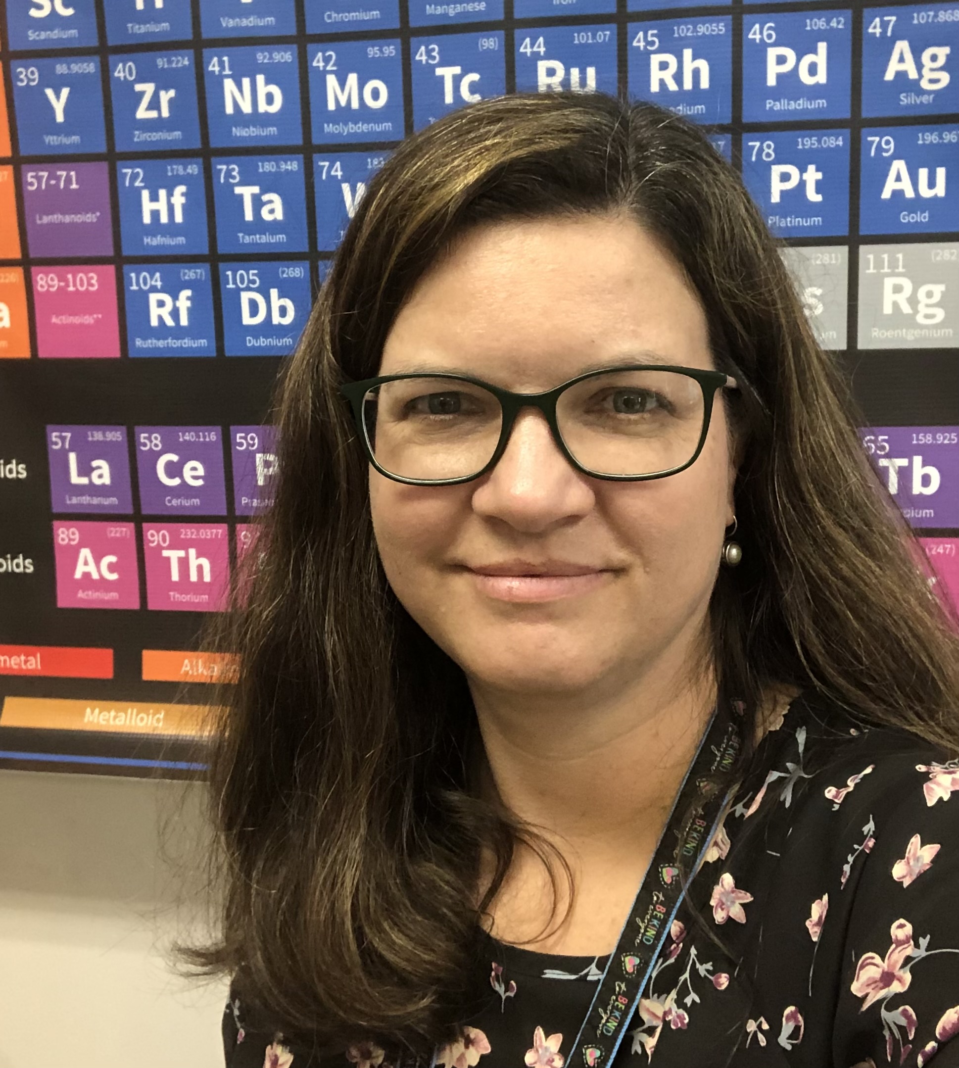 Headshot of a woman in front of a periodic table