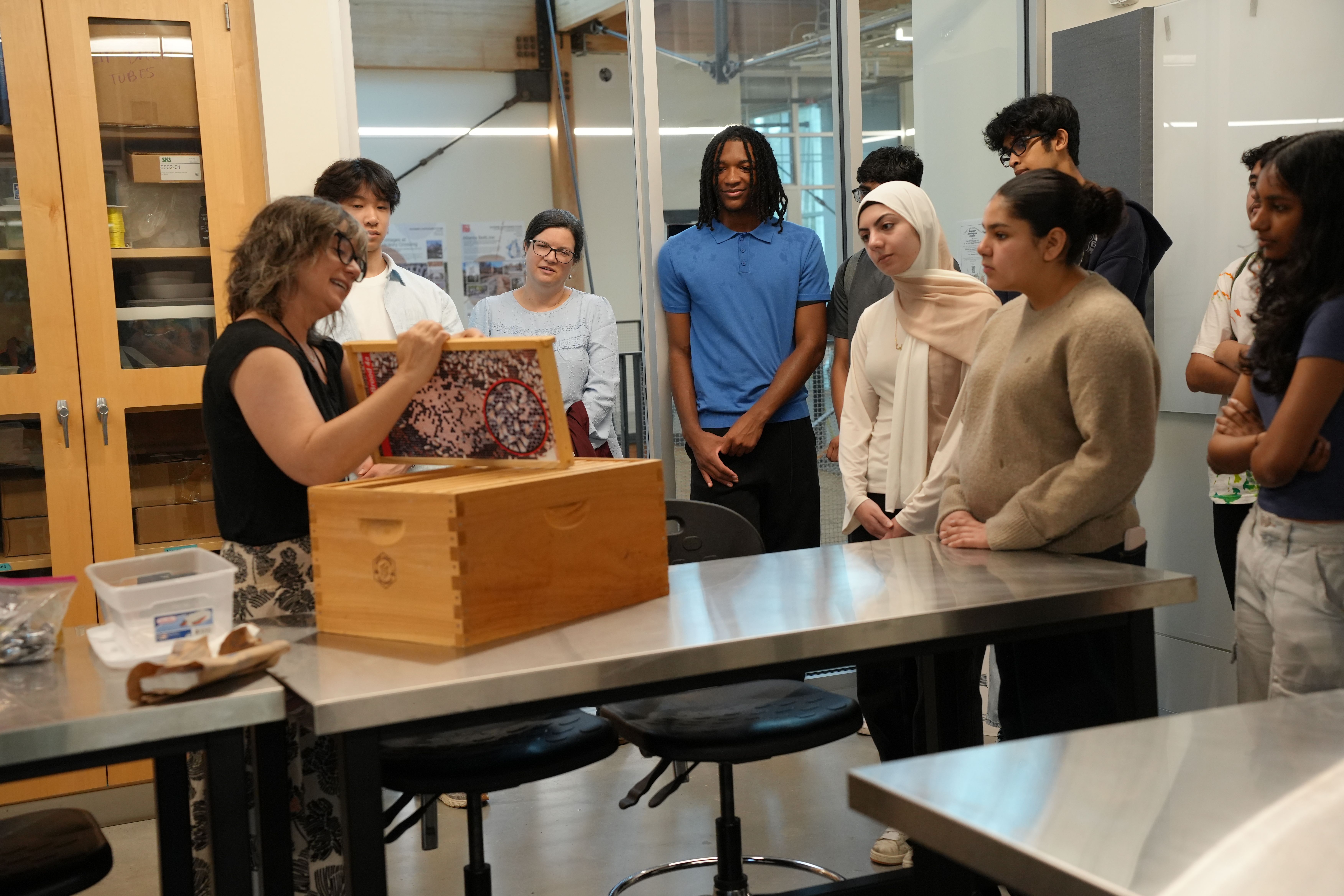 Woman demonstrates parts of a bee hive.