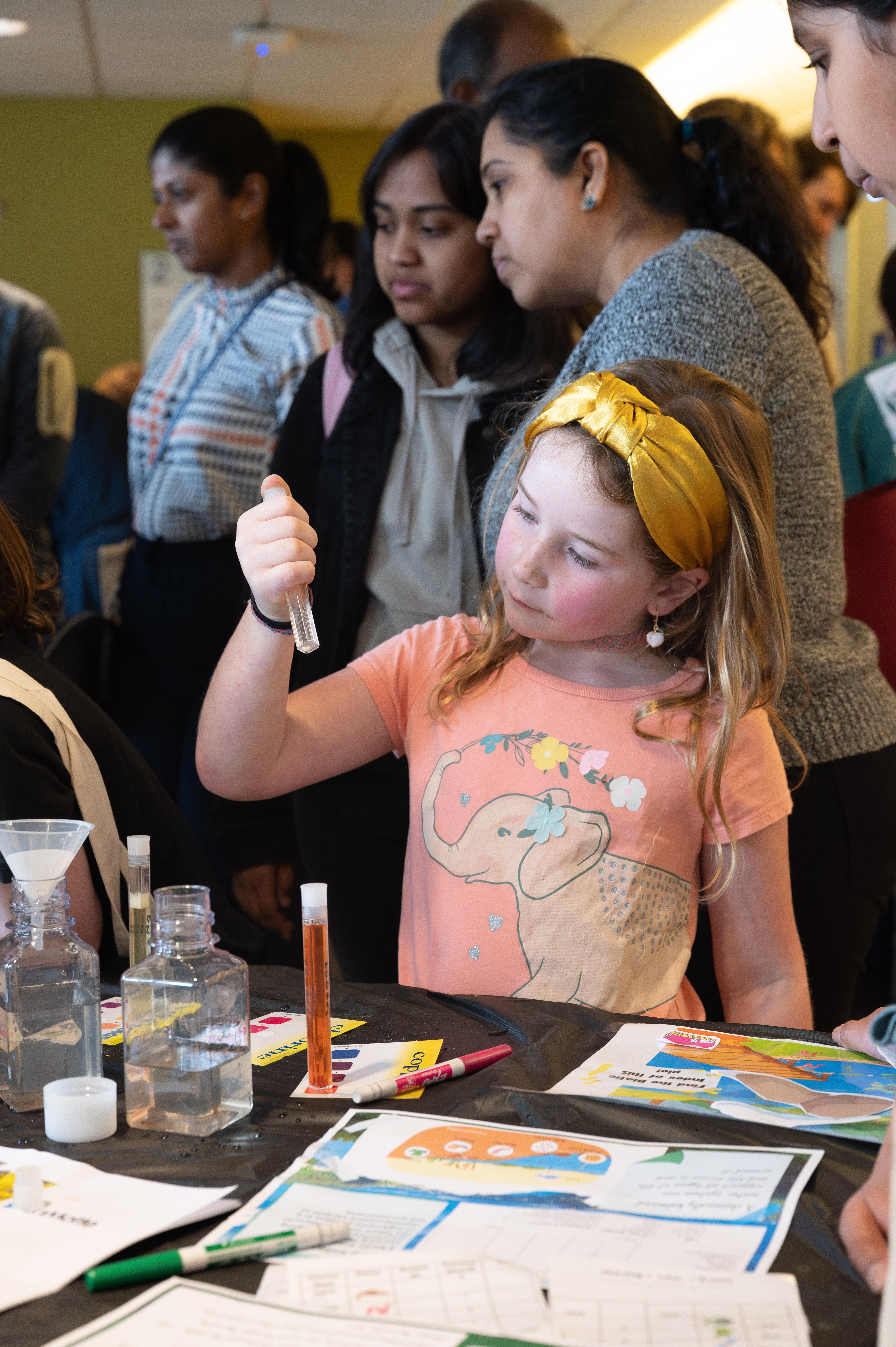 This guest at Science and Engineering Day examines tiny living organisms in a test tube. (Credit: Joya Chapman)
