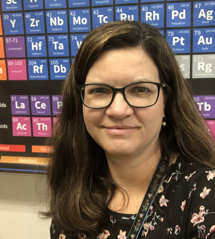 Headshot of a woman in front of a periodic table